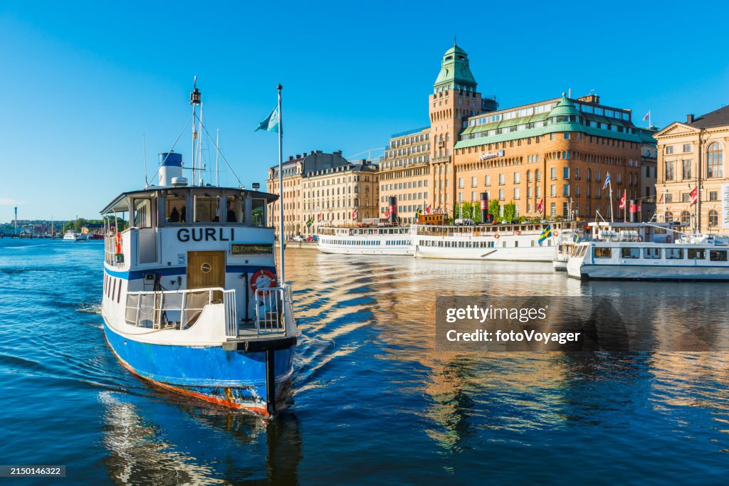 Stockholm ferry across harbour sailing beside city waterfront Sweden