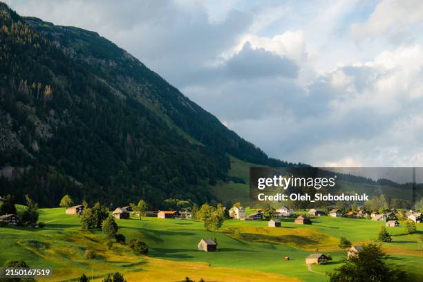 idyllisches dorf in den schweizer alpen im sommer - berner oberland stock-fotos und bilder