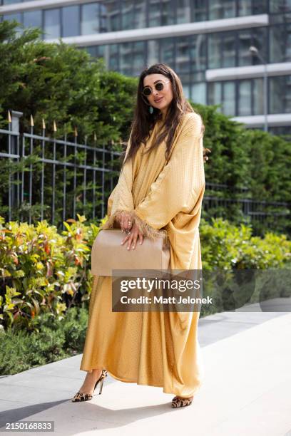 Aza Umarova is seen wearing a gold kaftan and gold bag at Istanbul Modest Fashion Week 2024 at Fisekhane Gallery on April 25, 2024 in Istanbul,...