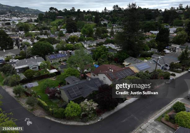 In an aerial view, solar panels are seen on the roofs of homes in a neighborhood on April 25, 2024 in San Rafael, California. California has cut back...