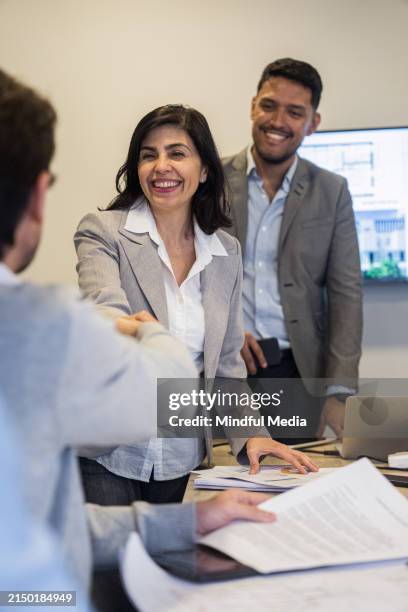 two cheerful real estate agents shaking hands with investor - business relationship stock pictures, royalty-free photos & images