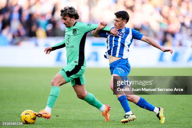 Antoine Griezmann of Atletico Madrid duels for the ball with Antonio Blanco of Deportivo Alaves during the LaLiga EA Sports match between Deportivo...