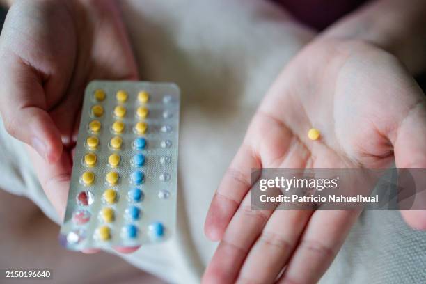 woman's health decision: unrecognizable female holding contraceptive pills, prioritizing reproductive well-being - birth control pill stock pictures, royalty-free photos & images