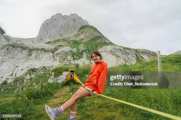 frau hat spaß an der slackline in den schweizer alpen - slackline stock-fotos und bilder