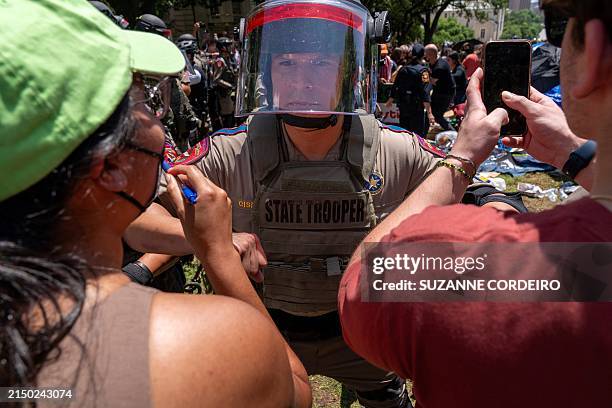 Pro-Palestinian protestors confront a Texas State trooper at the University of Texas in Austin, Texas, on April 29, 2024. The protests against...