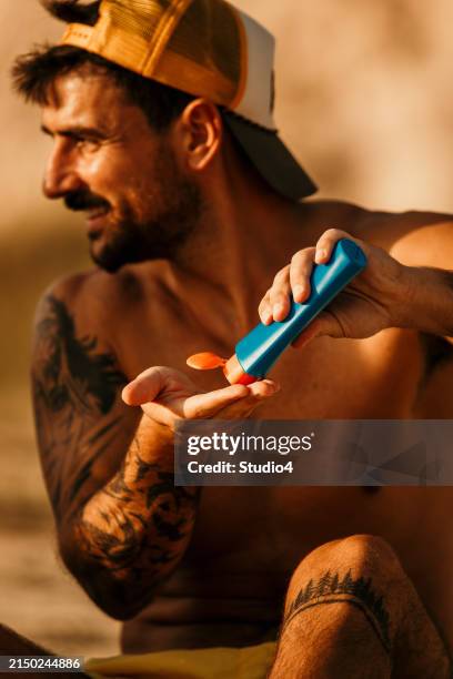 sun protection first - man sunscreen stock pictures, royalty-free photos & images