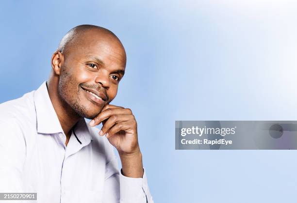 handsome man looks happy and contented on a light blue background with copy space - collar stock pictures, royalty-free photos & images