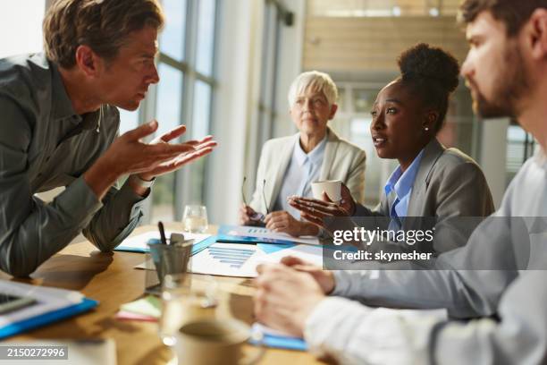 displeased business colleagues talking about problems on a meeting in the office. - communication problems stock pictures, royalty-free photos & images