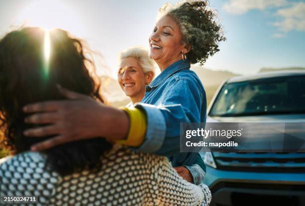 smiling mature women standing together by a scenic coast during a road trip - lifestyle imagens e fotografias de stock