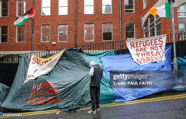 People stand by rows of tents, near the International Protection Office in Dublin on April 30 which has become a tented village with migrants and...