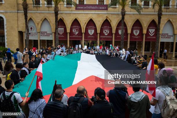 Students at the American University of Beirut unfurl a large Palestinian flag while they protest the war in Gaza in solidarity with students across...