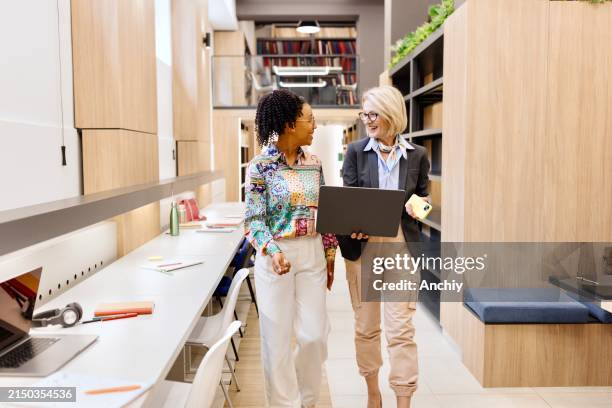 female professors talking about something at the library - professor da faculdade imagens e fotografias de stock