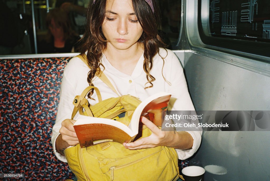Frau liest Buch in U-Bahn