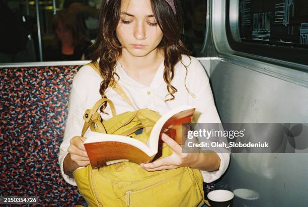 woman reading book in subway - arkiv bildbanksfoton och bilder
