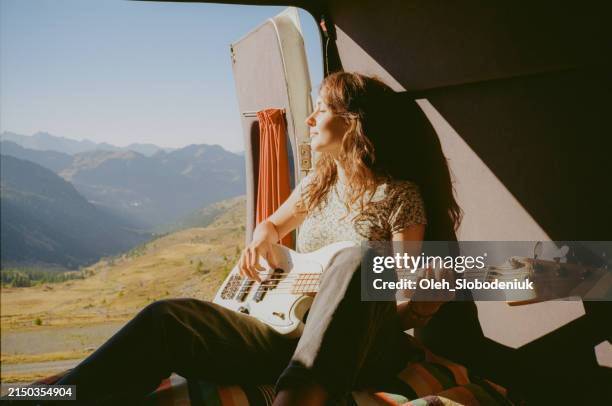woman with guitar in camper van in mountains - instrumento-de-corda imagens e fotografias de stock