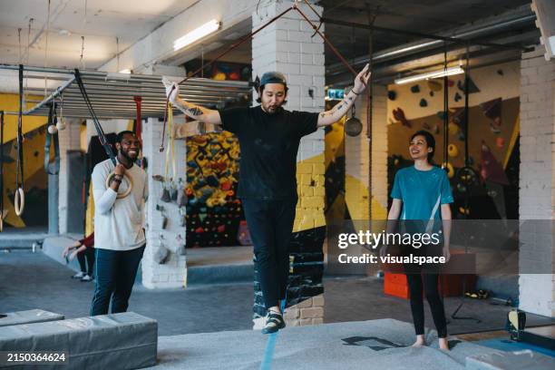 japanese man trying his balance on a slackline - slacklining stock pictures, royalty-free photos & images