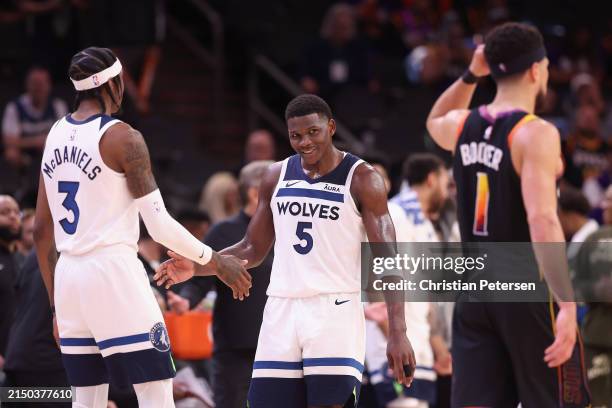 Anthony Edwards of the Minnesota Timberwolves celebrates with Jaden McDaniels ahead of Devin Booker of the Phoenix Suns during the second half of...