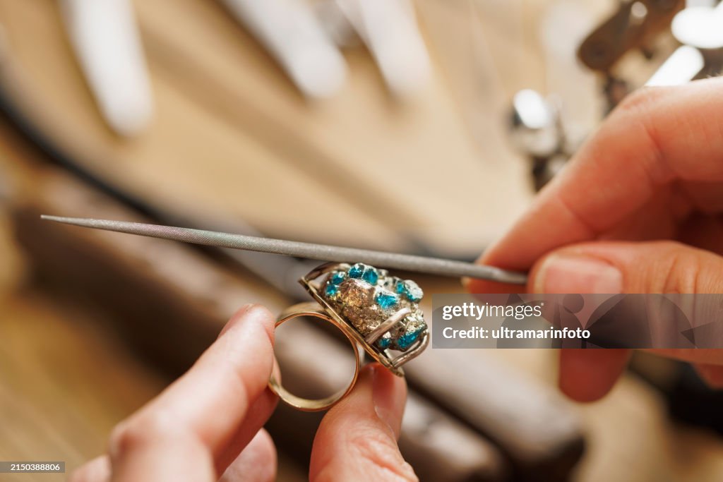 Juwelierin, stellt einen handgefertigten Ring her, verwendet Metallraspel. Juwelier-Handwerkswerkstatt