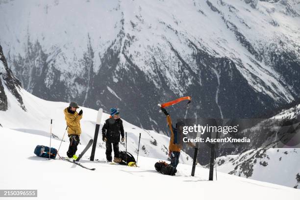 backcountry skiers prepare to ski down mountain - esqui fora de pista imagens e fotografias de stock
