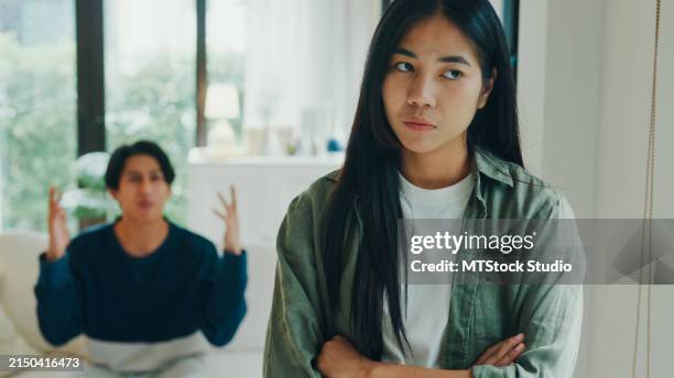joven pareja asiática enojada, preocupada, peleando, discutiendo en la sala de estar de su casa. problemas en la relación. - quejándose fotografías e imágenes de stock