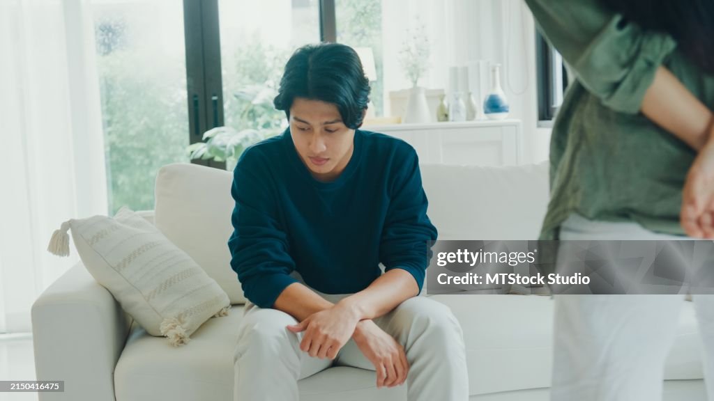 Closeup de jovem casal asiático irritado preocupado brigando discutindo na sala de estar em casa. Problemas de relacionamento.