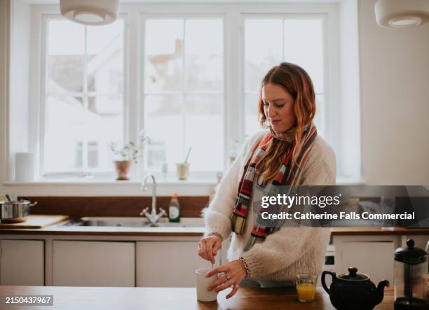 a woman prepares a cup of tea - mug stock pictures, royalty-free photos & images