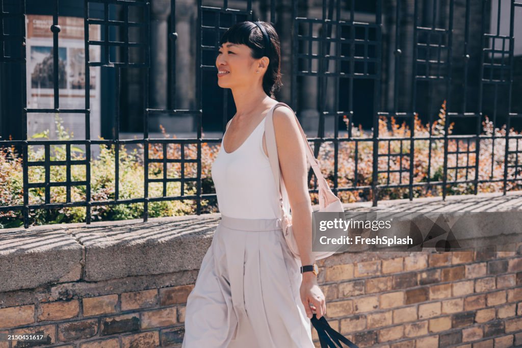 Elegant Woman Walking on Sunny City Street