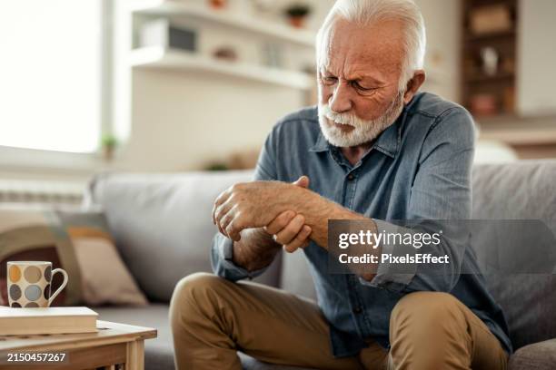 elderly male patient suffer from numbing pain in hand - inflamação imagens e fotografias de stock