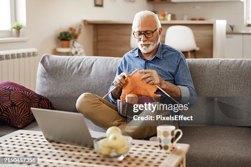 Senior Man Doing Knit Work While Watching Online Tutorial Senior Man Doing Knit Work While Watching Online Tutorial