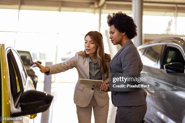 female vehicle dealer showing woman new car - full suit stock pictures, royalty-free photos & images
