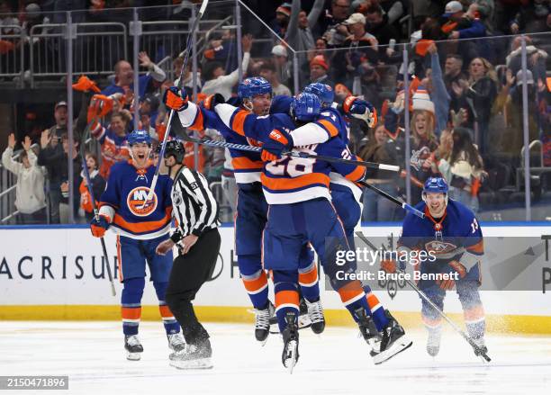 The New York Islanders celebrate their victory over the Carolina Hurricanes in double overtime in Game Four of the First Round of the 2024 Stanley...