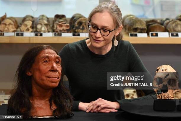 Associate Professor in the Evolution of Health, Diet and Disease, Dr Emma Pomeroy, poses for a photograph with the rebuilt skull and a physical...