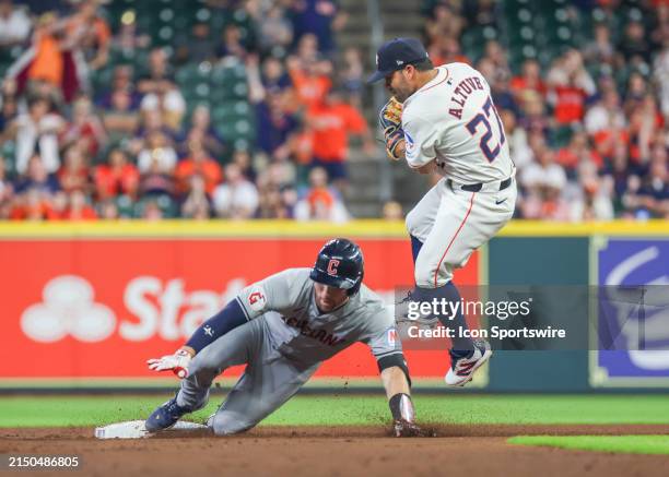 Houston Astros second base Jose Altuve jumps away from Cleveland Guardians catcher David Fry after tagging him at second base in the top of the...
