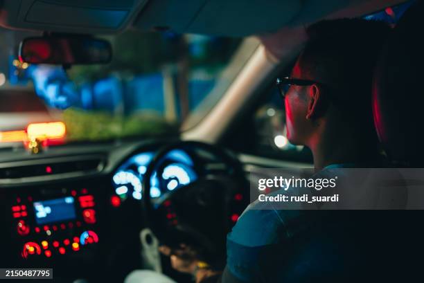 rückansicht eines mannes, der ein auto fährt - taxifahrer stock-fotos und bilder