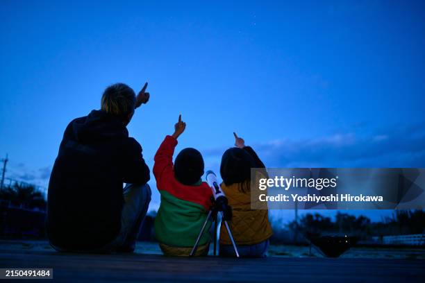 silhouette of father and son pointing to sky in search of first star with hope in their hearts. - astronomy stock pictures, royalty-free photos & images