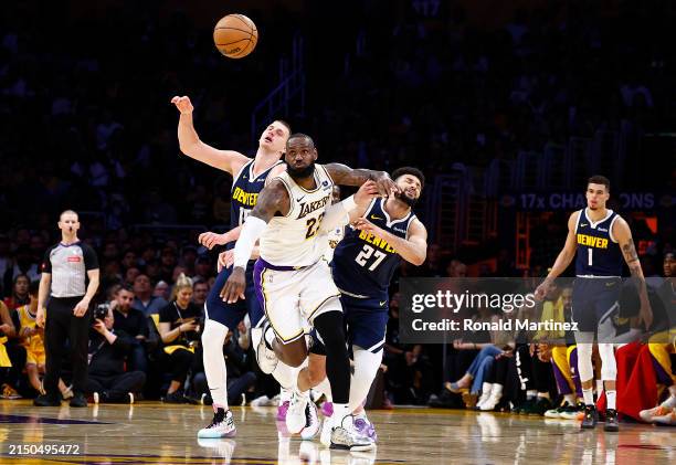 LeBron James of the Los Angeles Lakers steals the ball in front of Nikola Jokic and Jamal Murray of the Denver Nuggets in the second half during game...