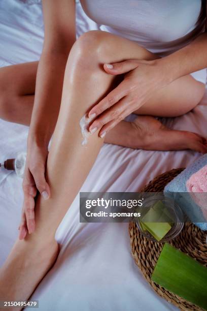 hispanic junge frau feuchtigkeitsspendende beine mit aloe vera naturgel - aloe vera gel stock-fotos und bilder
