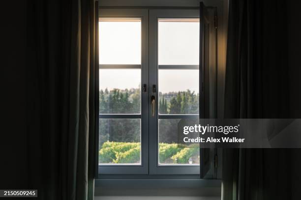 sunset view through window of with vineyards in rural tuscany, italy - janela imagens e fotografias de stock