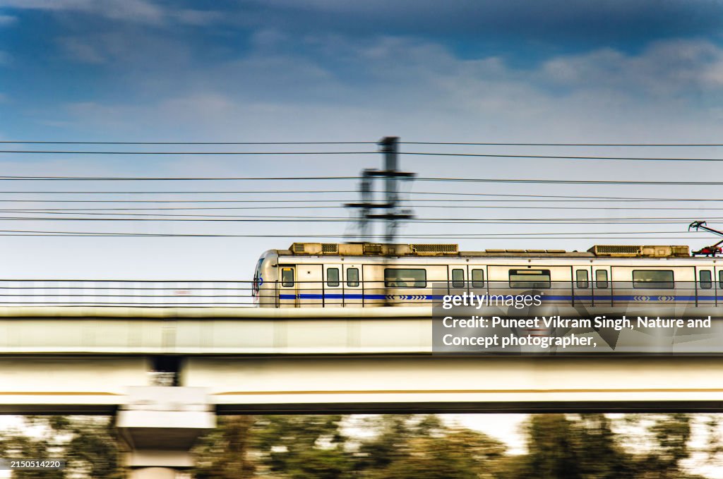 A speeding New Delhi Metro Train running on its elevated track.