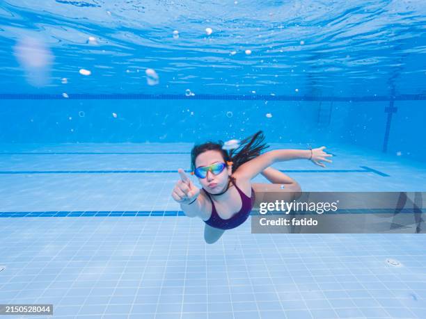 little girl having fun swimming underwater - kid reaction portrait stock pictures, royalty-free photos & images
