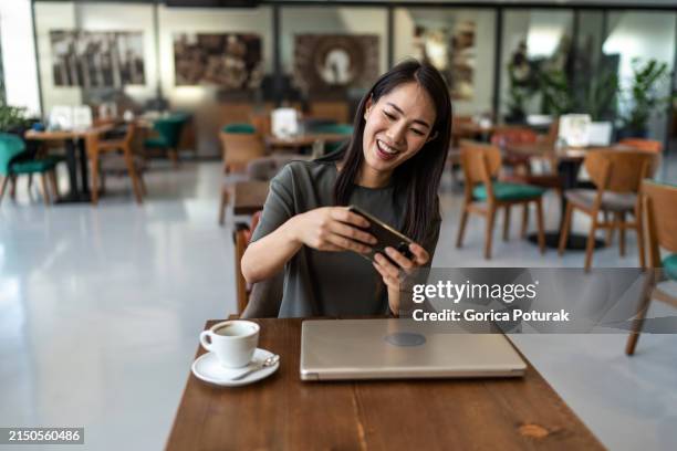 femme d’affaires jouant à des jeux vidéo sur smartphone - jeu mobile photos et images de collection