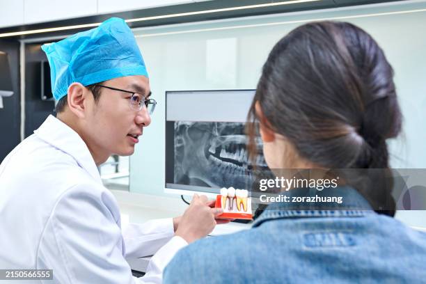 zahnarzt und patientin diskutieren lösung in zahnarztpraxis - dentalimplantat stock-fotos und bilder