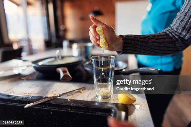 teenage girl squeezing lemon for vinaigrette sauce. - squeezing stock pictures, royalty-free photos & images