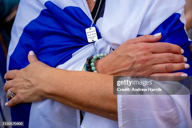 Woman wears the Israeli flag and a necklace that reads "Bring Them Home" during a rally against campus antisemitism at George Washington University...