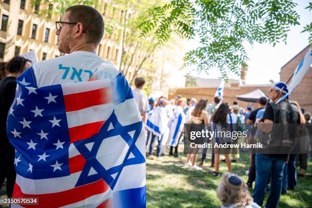 Man wears an American and Israeli flag as he attends a rally against campus antisemitism at George Washington University on May 2, 2024 in...