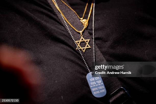 Woman wears the Star of David and another necklace that reads "Bring Them Home Now!" during a rally against campus antisemitism at George Washington...