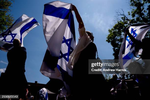 Michal Rokah of Falls Church, Virginia , Israeli Matan Showstack of Washington, DC , and others dance and wave large Israeli flags during a rally...