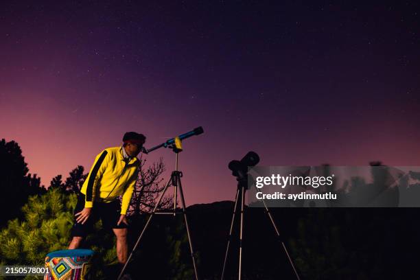 astronomer looking at the starry skies with a telescope - sky-scanner stock pictures, royalty-free photos & images