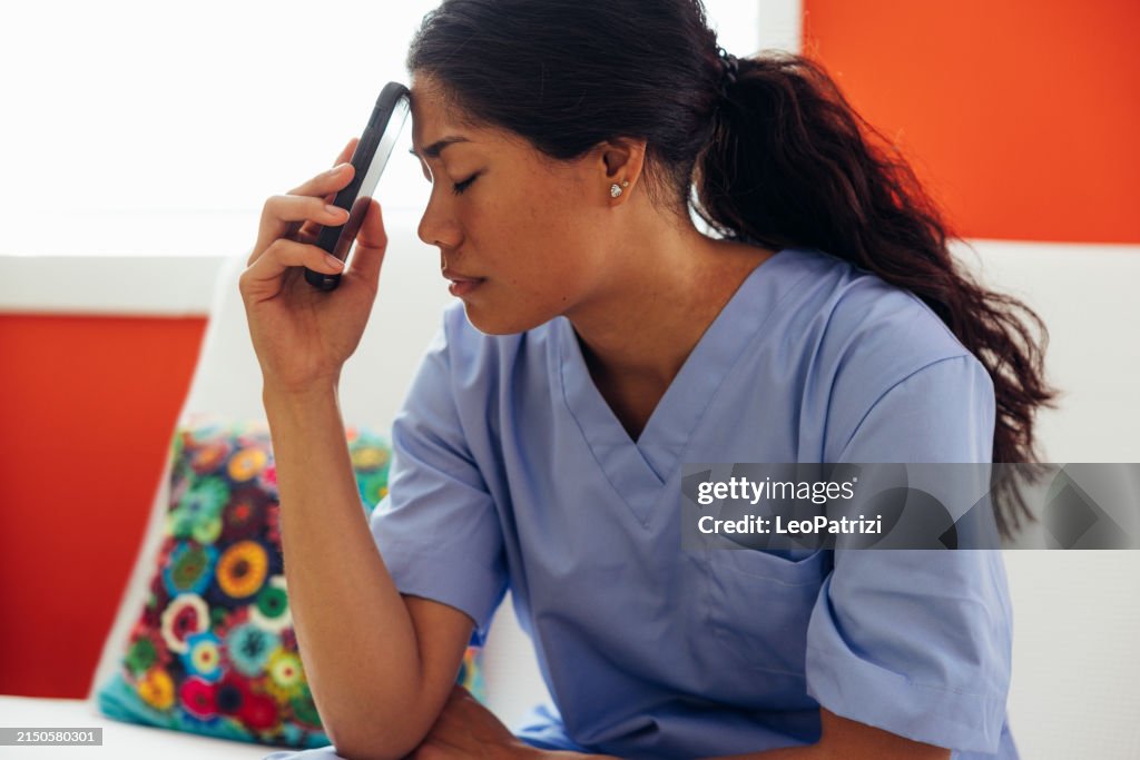 Exhausted nurse sitting on a sofa after a bad news