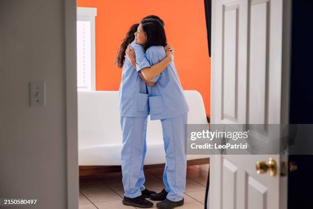 two young nurses hugging together - nurses hugging stock pictures, royalty-free photos & images